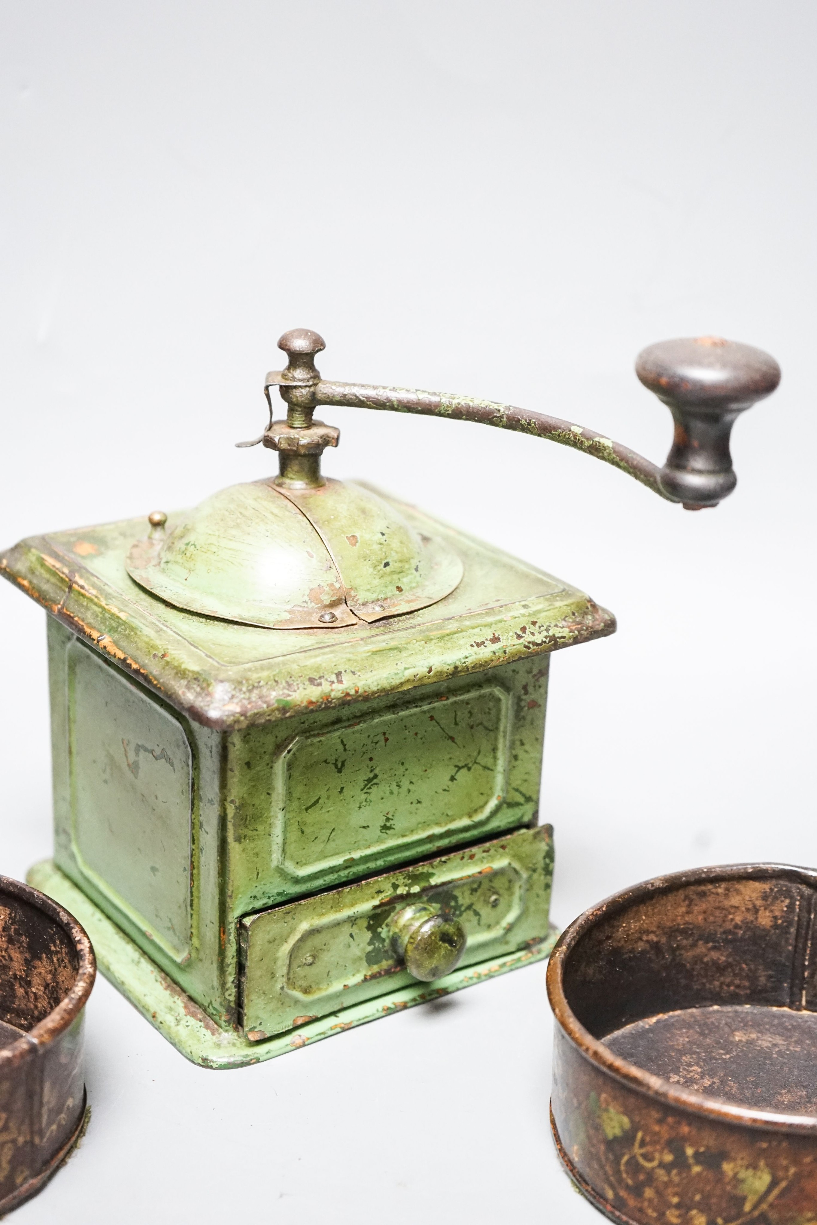 A pair of 19th century toleware coasters and a painted coffee grinder